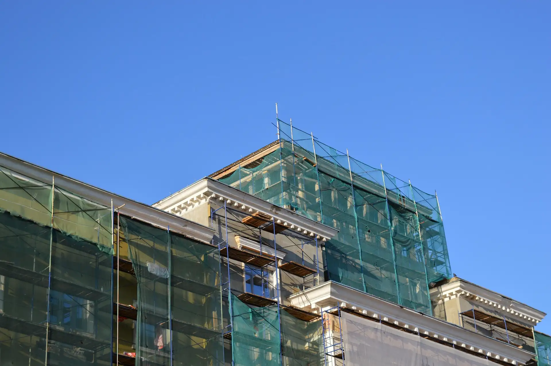 Netted facade scaffolding system by San Fernando Valley Scaffolding for debris control and worker safety